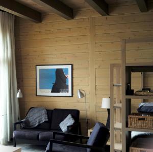 uma sala de estar com um sofá e uma fotografia na parede em Refuge du Cap em Baie-Saint-Paul