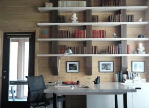 an office with a desk and a chair and book shelves at Refuge du Cap in Baie-Saint-Paul