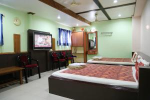 CuddaloreHotel Suriyapriya的带两张床的房间和带椅子的酒吧