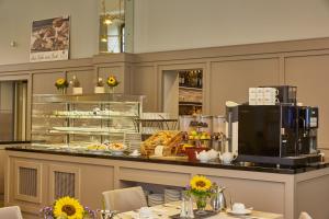 a restaurant with a counter with food on it at H4 Hotel Residenzschloss Bayreuth in Bayreuth