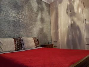 a bedroom with a bed with a red blanket at Sunny holiday home in Kalamata