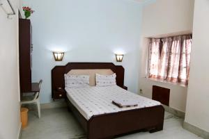 CuddaloreHotel Suriyapriya的带床和窗户的卧室