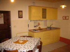 a kitchen with a table and a kitchen with yellow cabinets at Bed & Breakfast del Teatro in Cagli