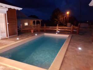 a swimming pool in a backyard at night at Villa piscine Ribourgeon in Saint-Louis