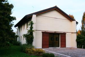 een klein wit gebouw met een grote deur bij Civico1A1 in Veternigo