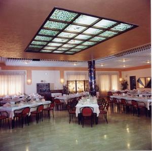 a dining room with tables and chairs and a large ceiling at Motel Forum in Polla
