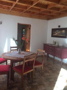 Cabaña Colibri في سان ألفونسو: غرفة طعام مع طاولة وكراسي وخزانة