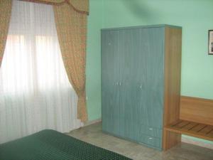 ポッラにあるMotel Forumのベッドルーム1室(窓の横に青いキャビネット付)