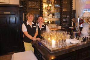 dos mujeres de pie detrás de un mostrador en un bar en Hotel Reuterhaus Wismar en Wismar
