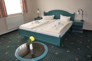 a room with a bed, a table, and a rug at Hotel Reuterhaus Wismar in Wismar