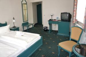 
a hotel room with two beds and a television at Hotel Reuterhaus Wismar in Wismar
