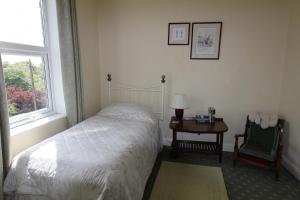 a bedroom with a bed and a table and a chair at Southfield House in Hornsea