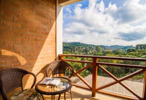a balcony with a table and chairs and a view at Pousada Suiça Mineira Centro in Monte Verde