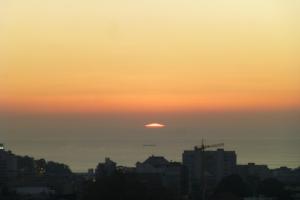 a sunset over a city with the sun in the sky at Apartamento Vintage 2 in Porto