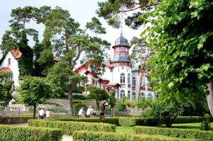 een groot wit huis met een toren bovenop bij Ferienwohnung Familie Böckmann im Ostseebad Zinnowitz auf Usedom in Zinnowitz