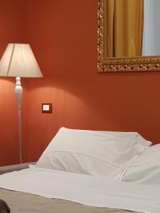 ラ・スペツィアにあるL'Etoileのベッドルーム(ベッド1台、鏡、ランプ付)