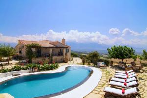 a swimming pool with lounge chairs and a house at Alexis Villa, refined holidays, By ThinkVilla in Episkopí- Rethimno