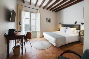 馬略卡島帕爾馬的住宿－卡納佛公寓式酒店，一间卧室配有一张床、一张桌子和一张桌子