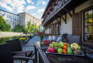 a tray of fruit on a table on a balcony at Garni hotel Castle Bridge in Český Krumlov