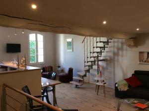uma sala de estar com uma escada em espiral numa casa em L'appart des Jacobins em Saint-Émilion