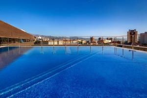 a large swimming pool with a view of a city at Allegro Granada in Granada