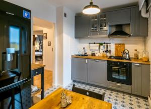 a kitchen with gray cabinets and a wooden table at Downtown Wonder Apartament in Cluj-Napoca