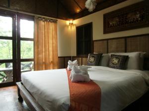 a bedroom with a bed with two stuffed animals on it at Marisa Resort & Spa Chiang Dao in Ban Muang Ngai