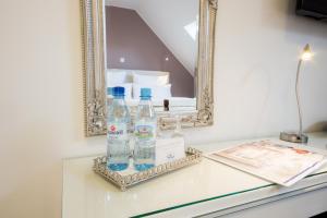 zwei Flaschen Wasser auf einem Tisch vor einem Spiegel in der Unterkunft Landhotel Alte Töpferei in Duisburg + 106 Fotos