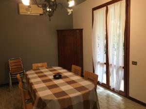 a dining room with a table and chairs and a window at Casa Bellodi in Novi di Modena