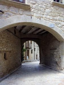 a stone wall with an archway in a building at La caseta de Pedris in Valderrobres