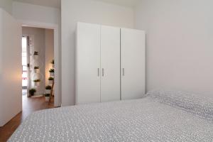 グラナダにあるtuGuest Ático Imprentaの白いベッドルーム(ベッド1台、白いキャビネット付)