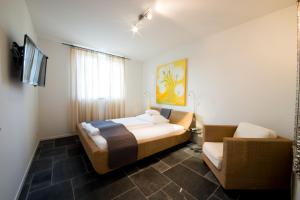 ein Schlafzimmer mit einem Bett und einer Couch in der Unterkunft Landhotel Alte Töpferei in Duisburg