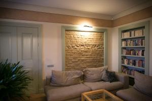 een woonkamer met een bank en een bakstenen muur bij Botique & SPA Hotel Berkenes Manor in Ziedkalne