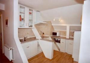 a white kitchen with white cabinets and a sink at Ferienwohnung Richter in Neundorf