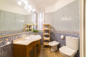 ein blau gefliestes Bad mit WC und Waschbecken in der Unterkunft El Jardín del Ángel Yolka in Madrid