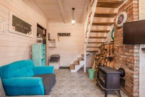 a living room with a blue couch and a stove at Prowansalskie Nuty in Sasino