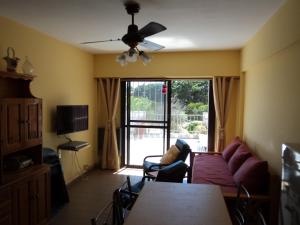 a living room with a couch and a table and a tv at Edificio Riazor n° IX in San Clemente del Tuyú