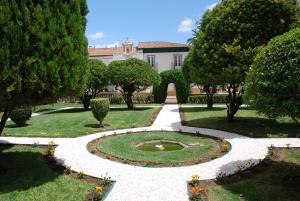 un jardin avec une fontaine et des arbres ainsi qu'un bâtiment dans l'établissement Monte da Amoreira, à Elvas