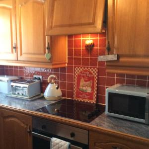 a kitchen with a counter top with a microwave at Achmelvich View self catering in Lochinver
