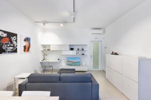 ein Wohnzimmer mit einem blauen Sofa und weißen Schränken in der Unterkunft Casetta sul mare A in Monopoli