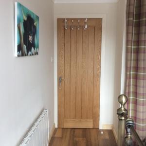 a hallway with a wooden door in a house at Achmelvich View self catering in Lochinver