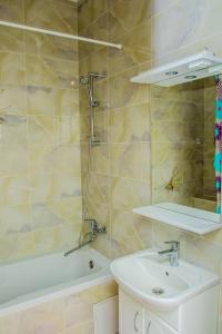 a bathroom with a shower and a sink and a tub at Apartments Manghilik El 53/66 in Astana