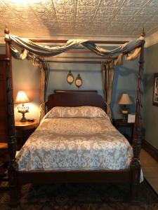 a bedroom with a canopy bed and two lamps at Penley House Bed & Breakfast in Auburn