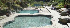 a large pool of water with people sitting around it at Eco Quechua Lodge in Santa Teresa
