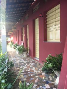 a pink house with a walkway in front of it at Algodoal Bela Mar Pousada in Algodoal