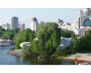 une vue sur une rivière avec une ville en arrière-plan dans l'établissement Green Stone, à Kiev