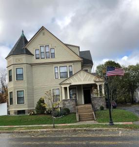 a house with an american flag in front of it at Penley House Bed & Breakfast in Auburn