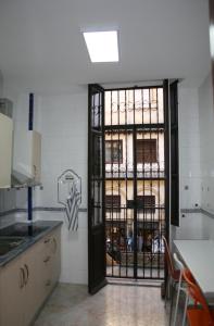 una cocina con una puerta que da a una habitación con una mesa en Alcaiceria, en Granada