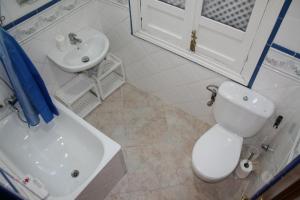 a bathroom with a white toilet and a sink at Alcaiceria in Granada