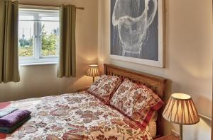 a bedroom with a bed and a window at Farthing Cottage in Norwich